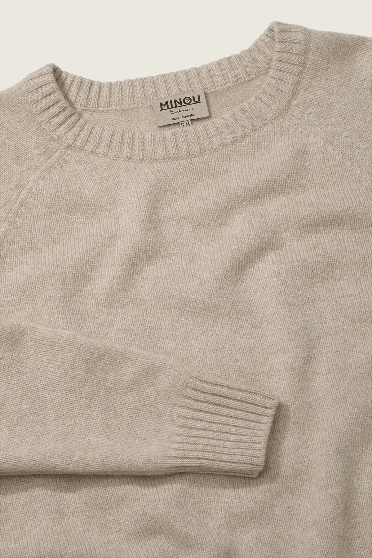 kaszmirowy krótki raglan w kolorze chłodnego beżu zbliżenie na detal